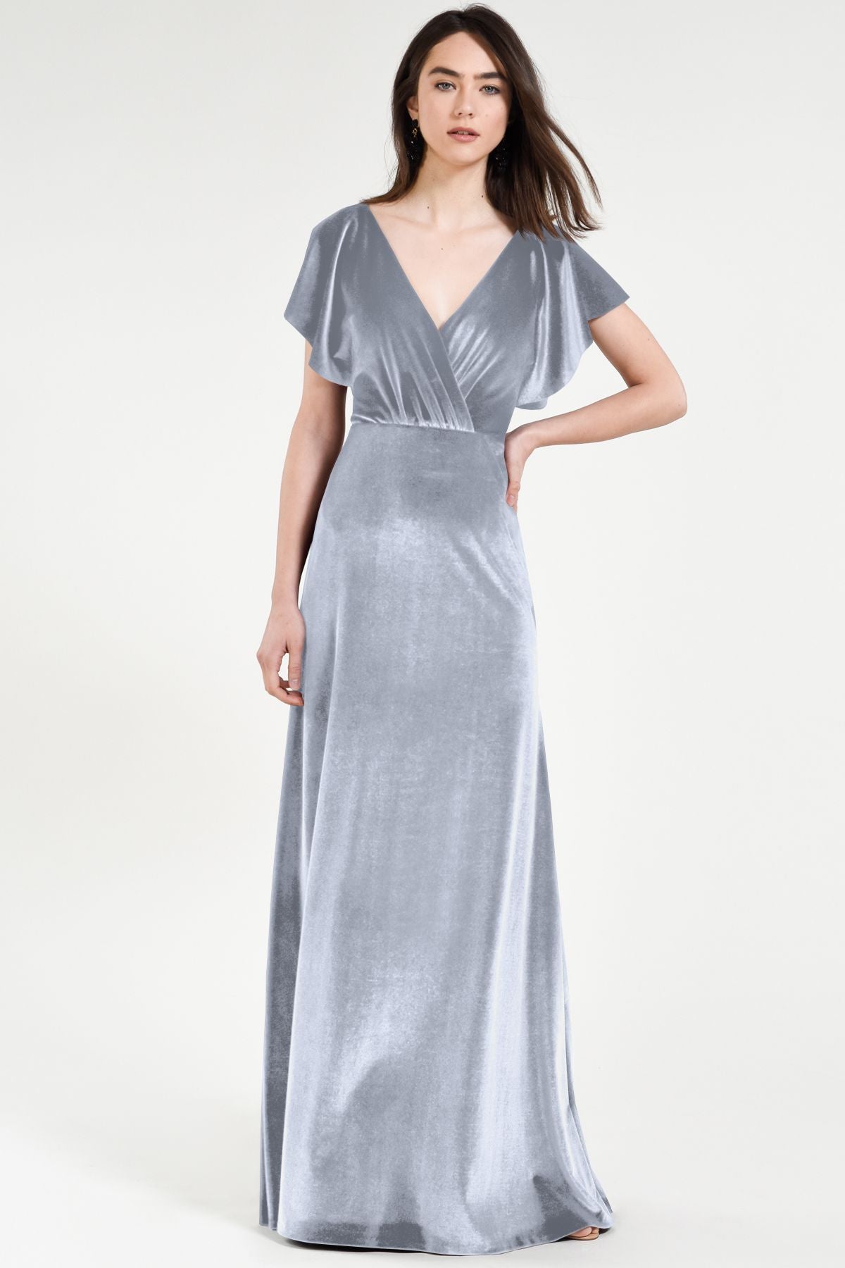 Woman wearing a silver evening gown on a white background
