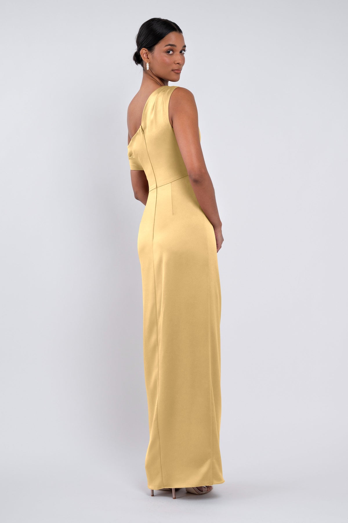 Woman wearing a yellow evening gown against a white background