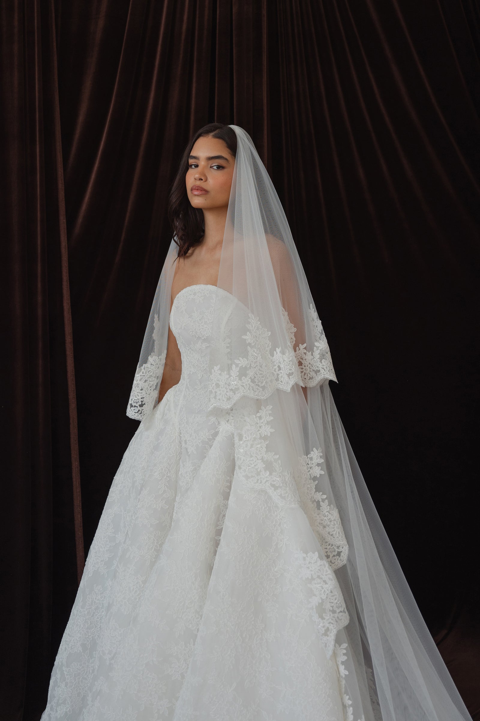 Lace and tulle cathedral length wedding veil and model in bridal gown.