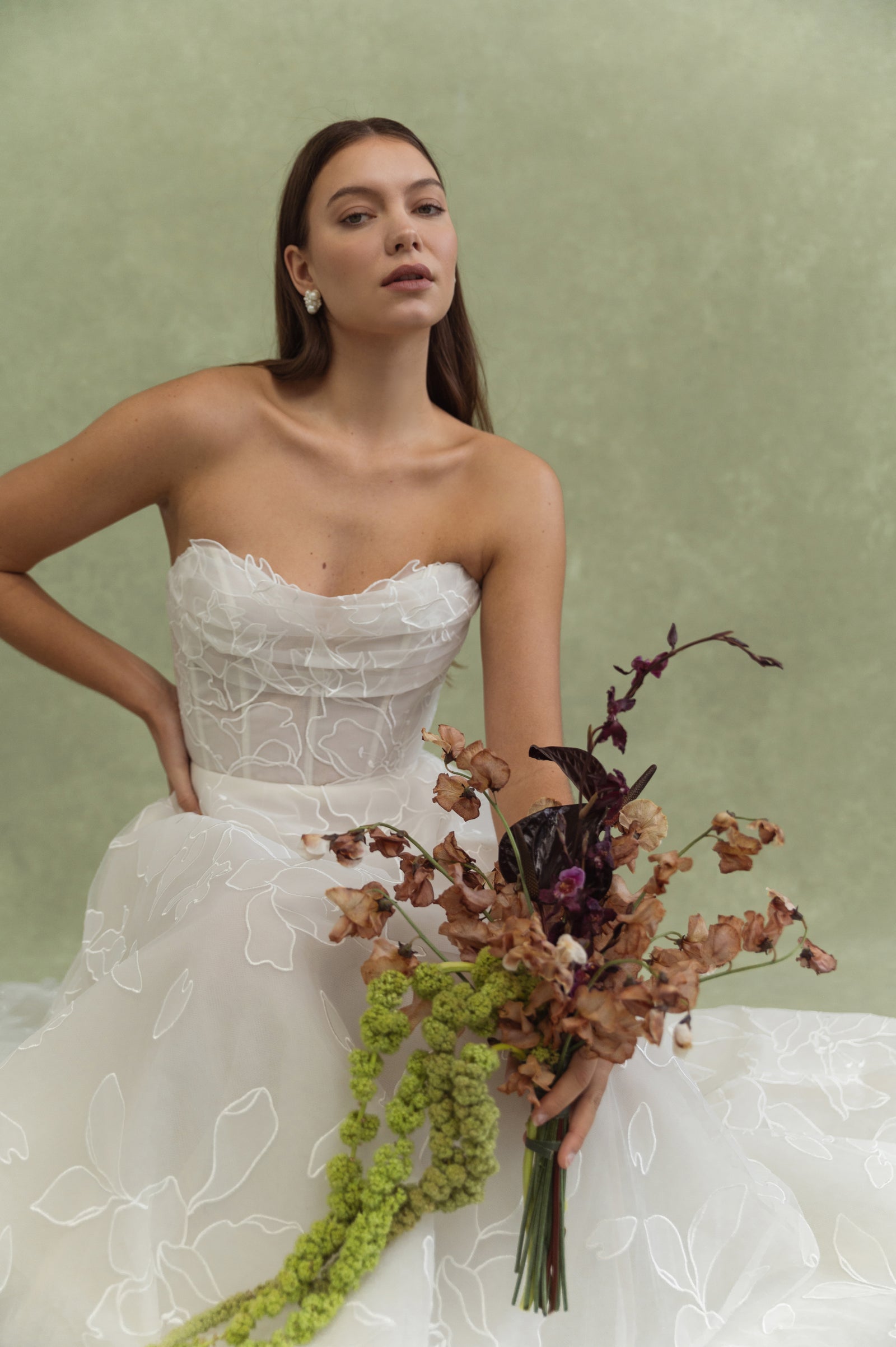 Bride in coastal setting wearing strapless simple crepe wedding dress.
