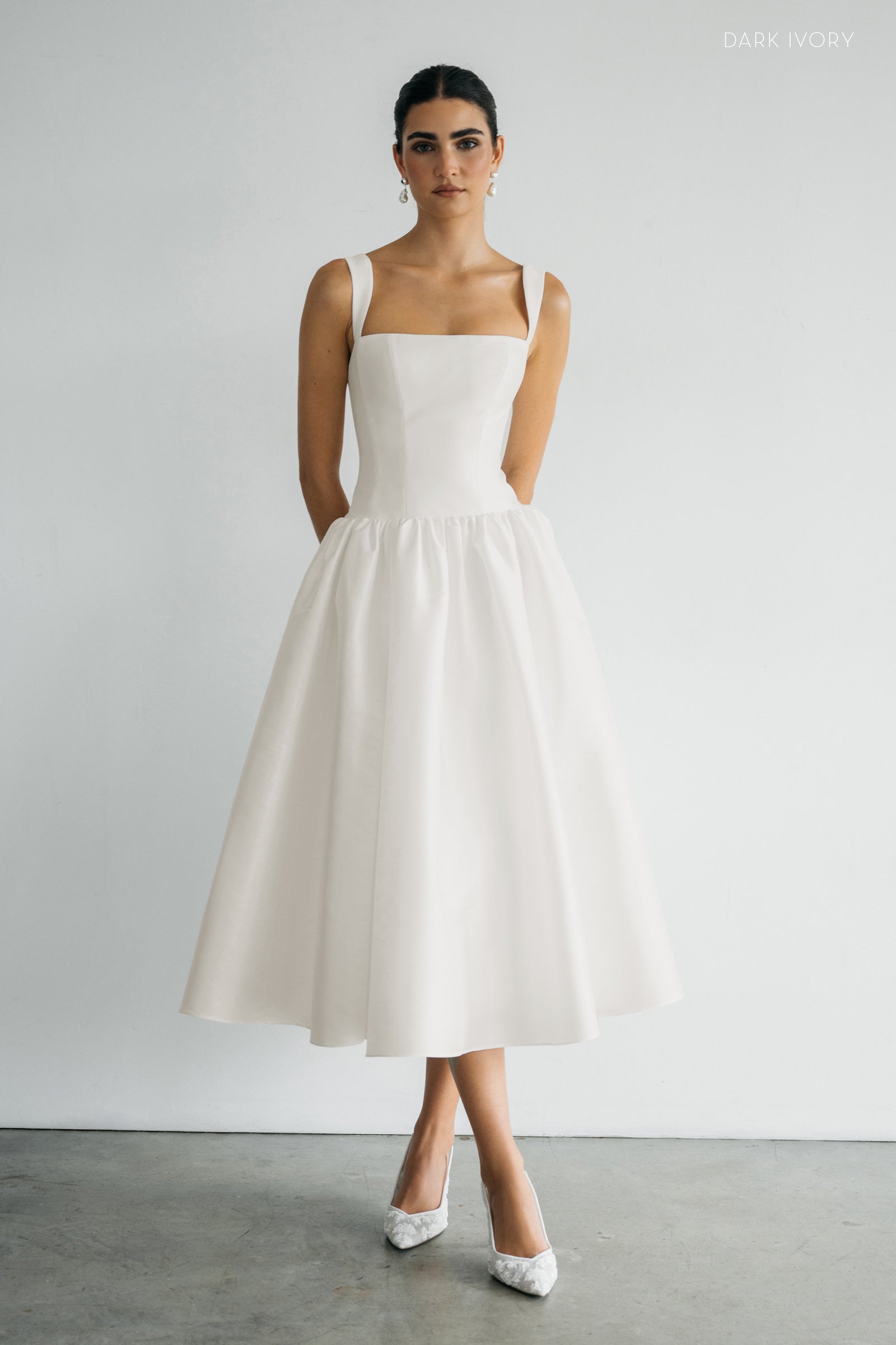 Lucille drop waist little white midi dress with straps and square neckline on model.
