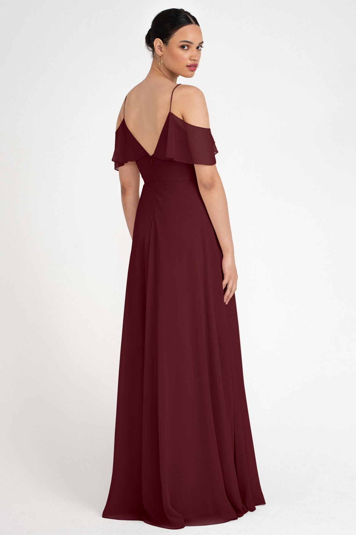 Woman wearing a burgundy off-shoulder gown on a white background