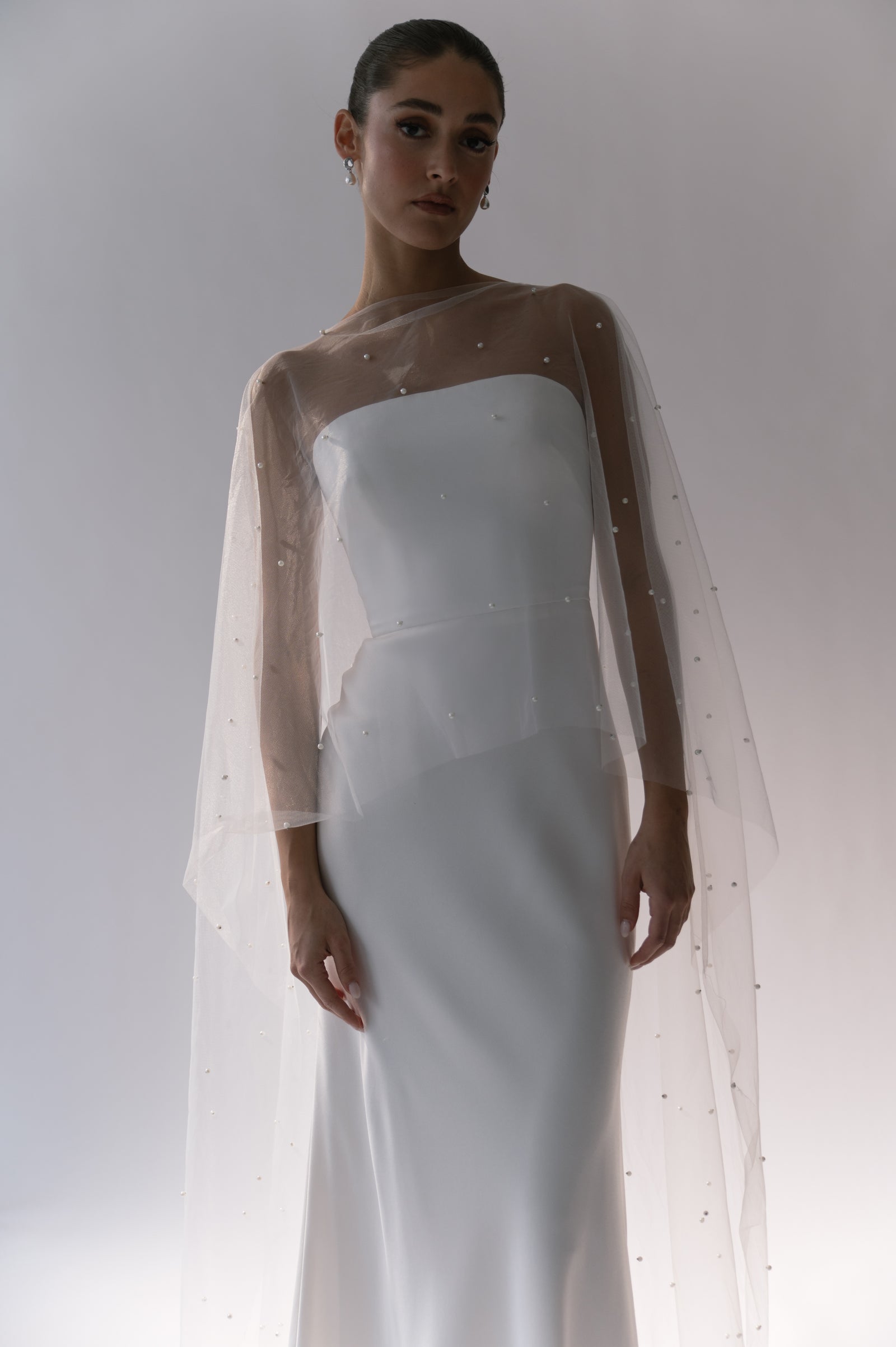 Bride Wearing Fitted Wedding Dress and Sheer Pearl Cape