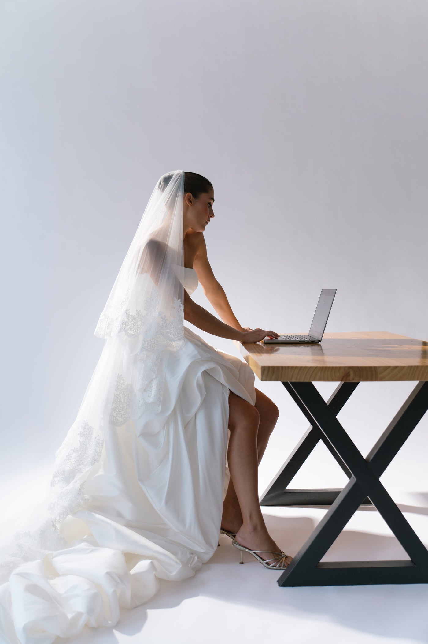Bride in Dress on Laptop at Table
