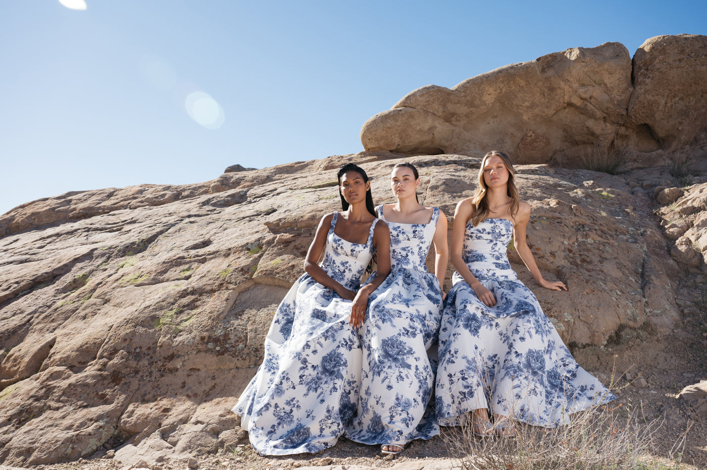 Three bridesmaids in floral blue and white printed taffeta dresses.