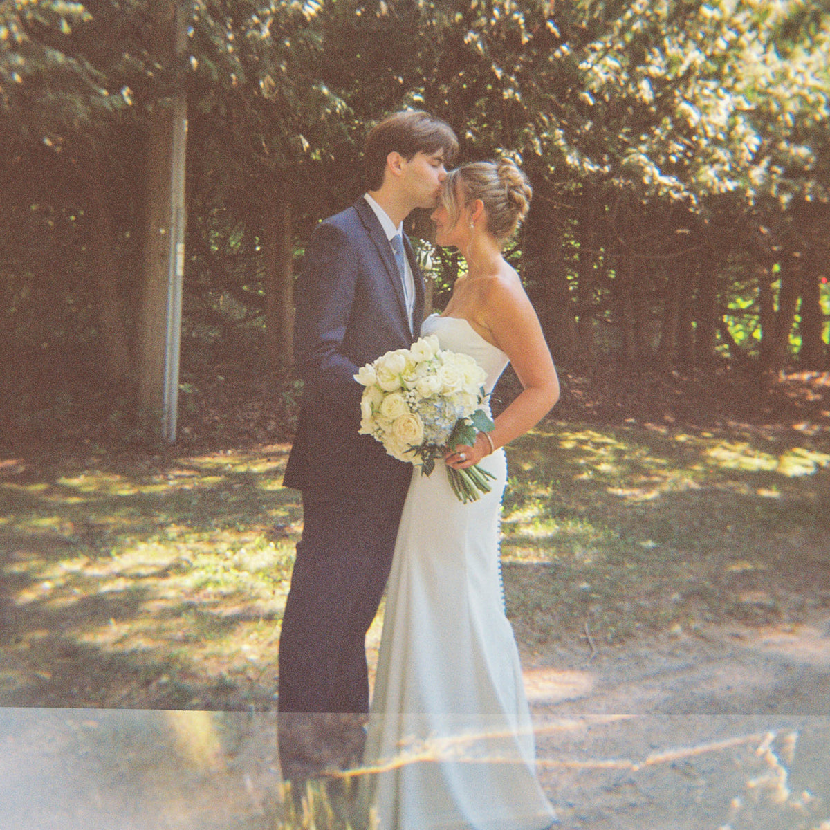 Real Bride Kate in the Timeless Tricia Strapless fit and flare wedding dress with floral applique.
