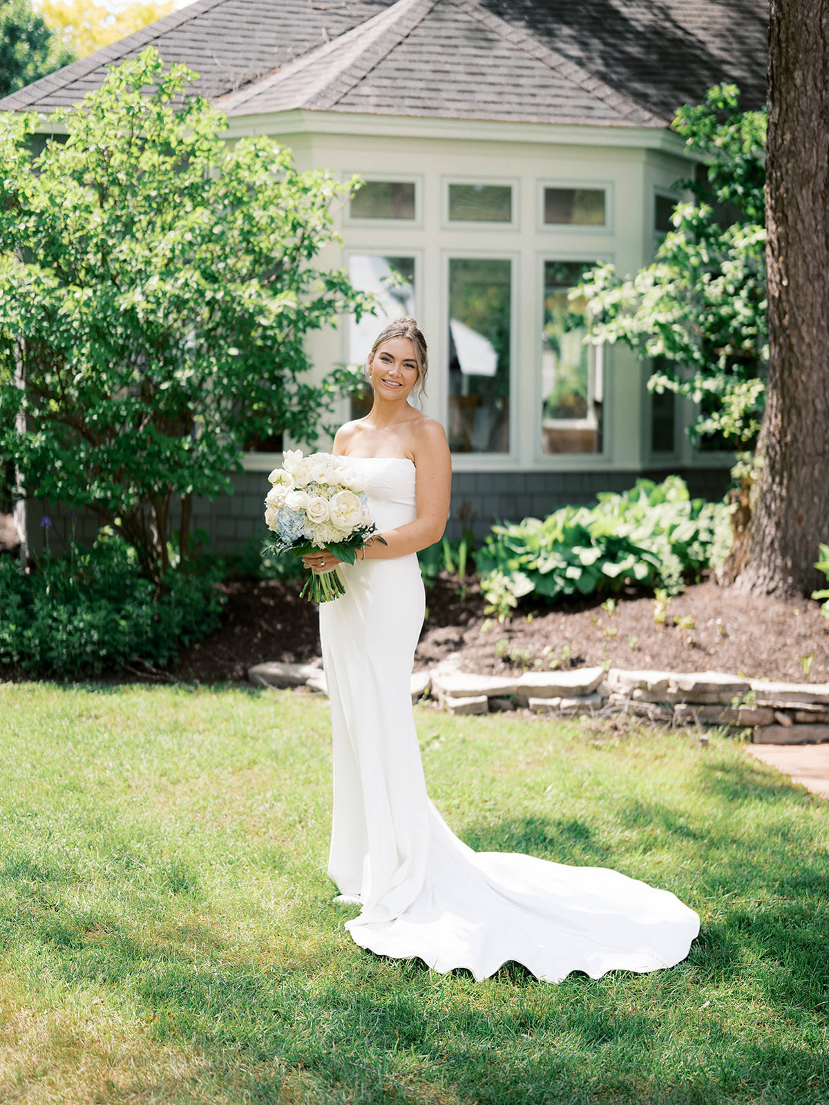 Real Bride Kate in the Timeless Tricia Strapless fit and flare wedding dress with floral applique.