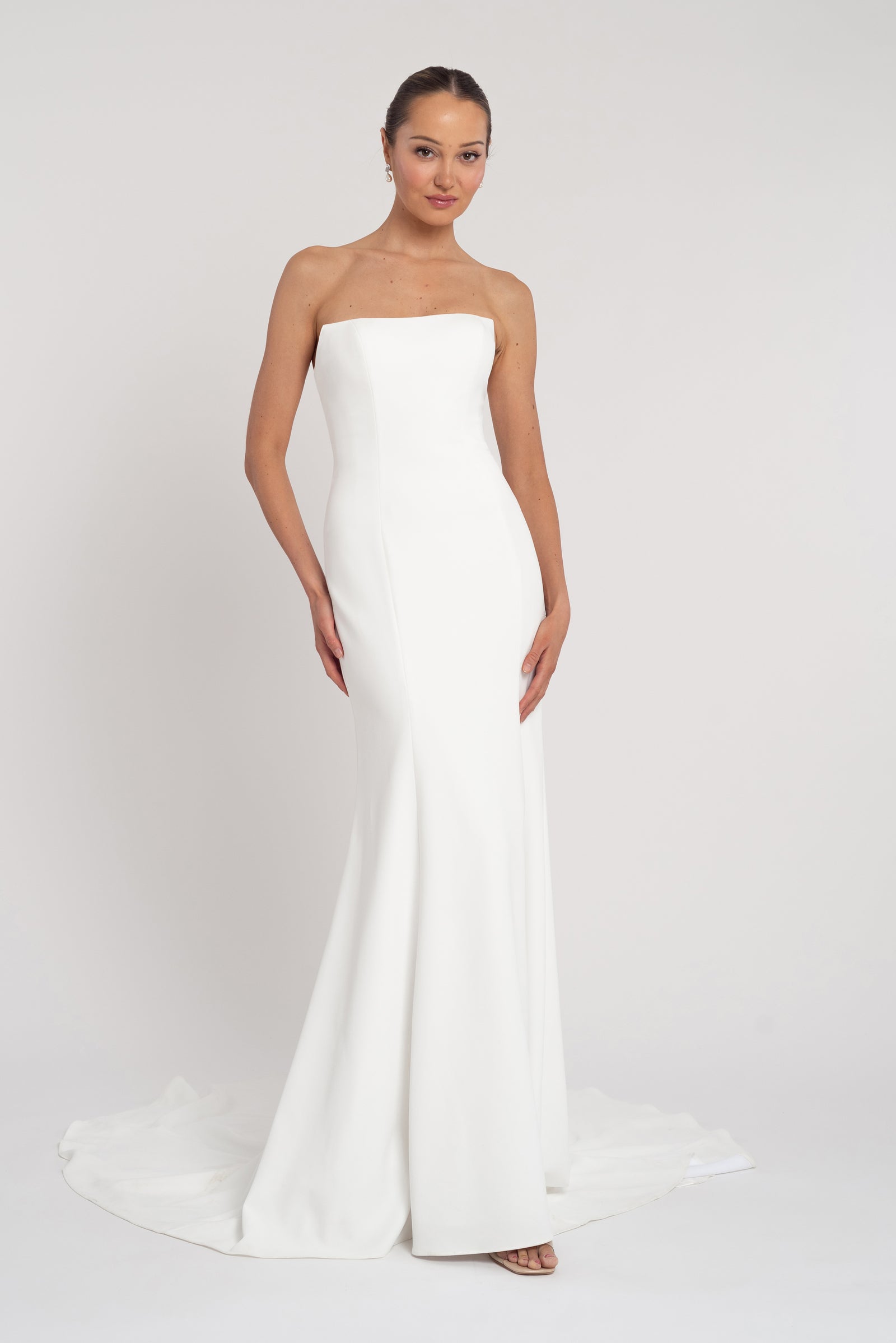 Strapless fit and flare floral bridal gown without waist seam on model.