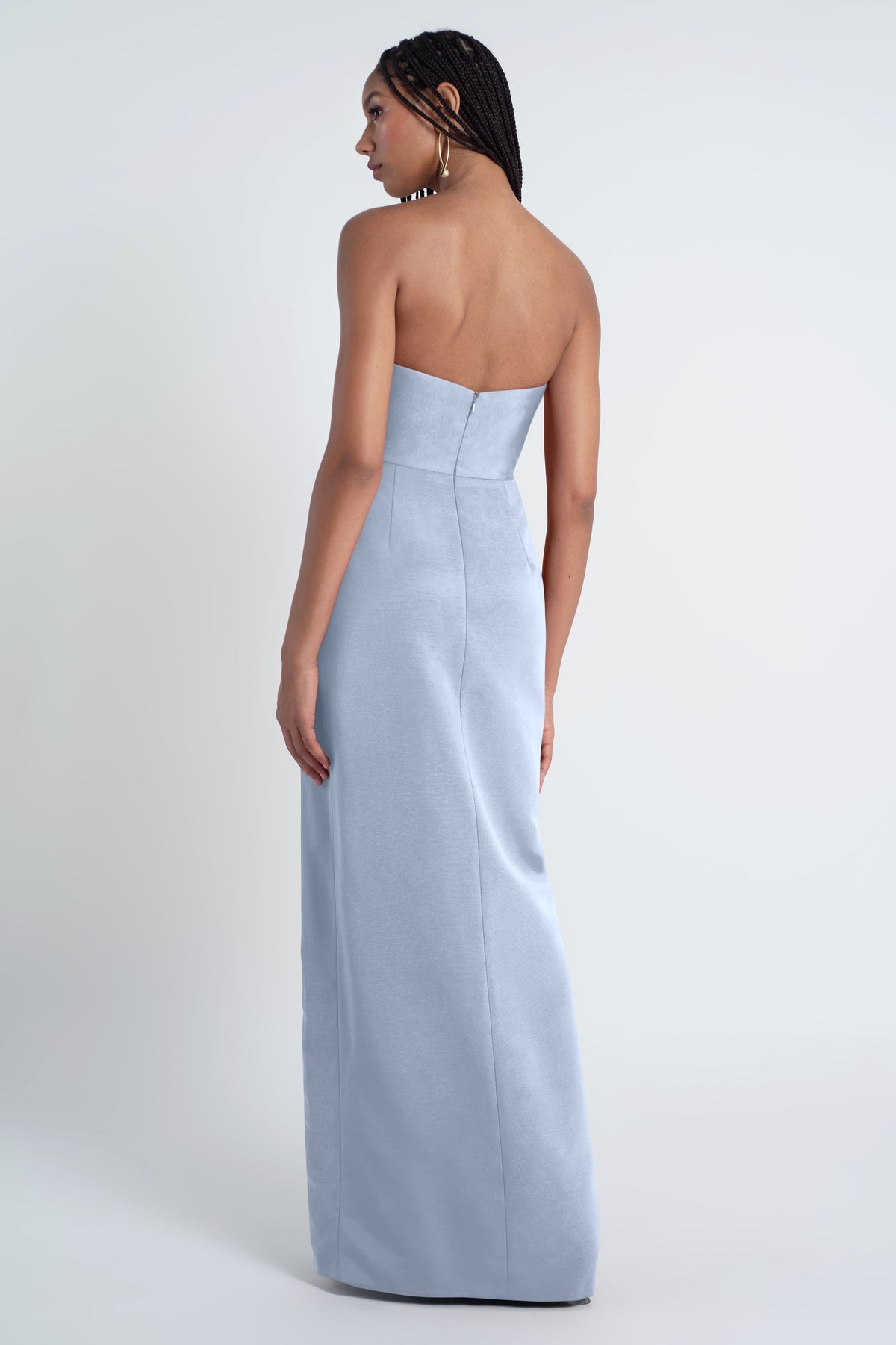 Woman wearing a light blue strapless gown on a white background