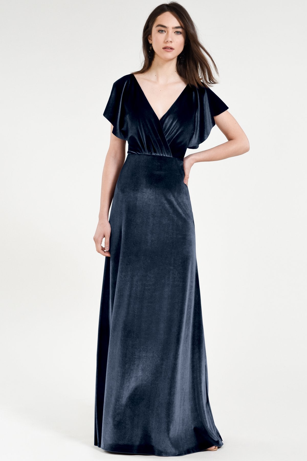 Woman wearing a black velvet evening gown on a white background